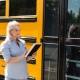 Teacher at school in front of the bus